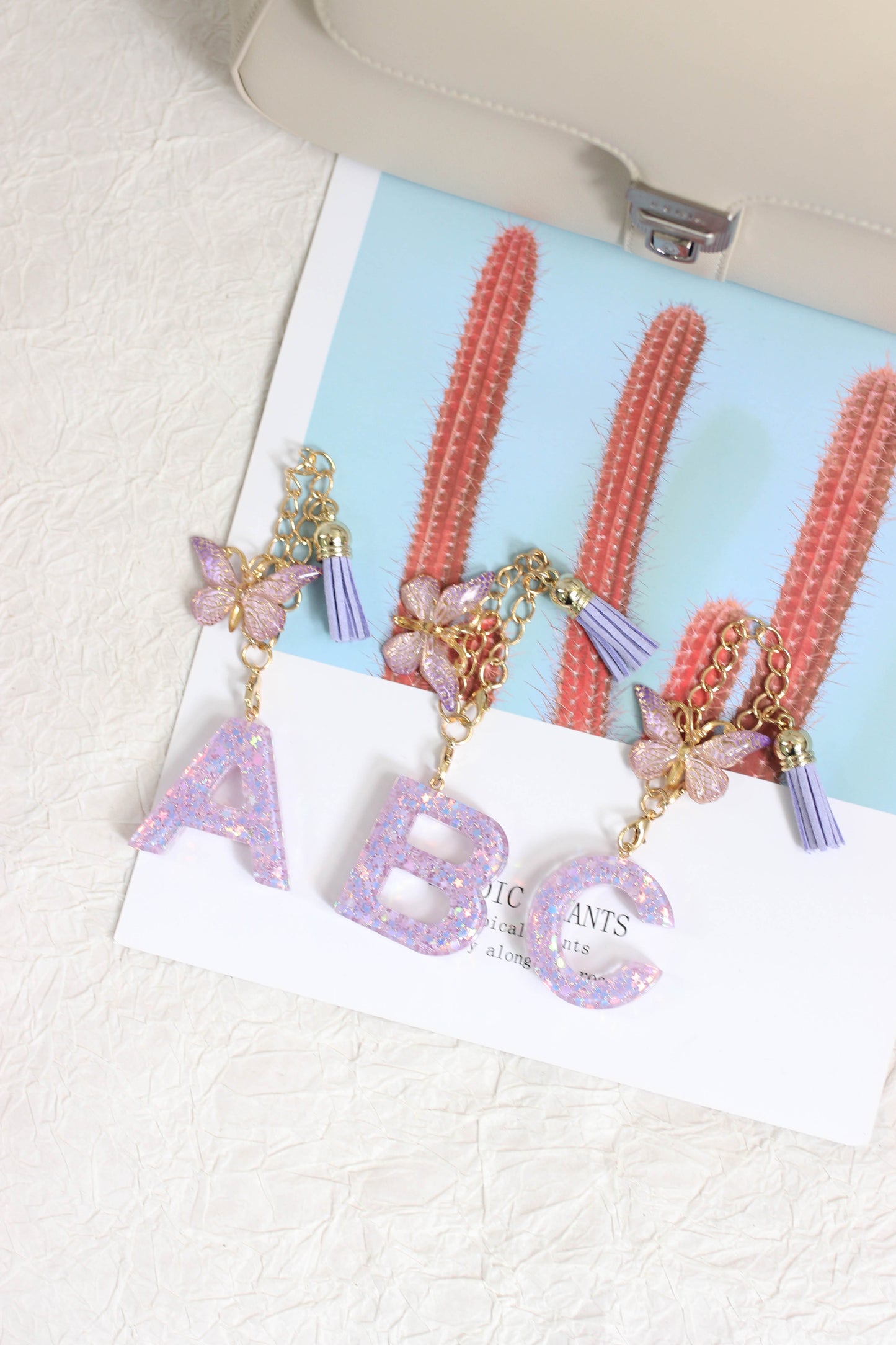 A2507HY68144 - Glitter Resin Letter Keychain ¨C Butterfly & Tassel Bag Charm